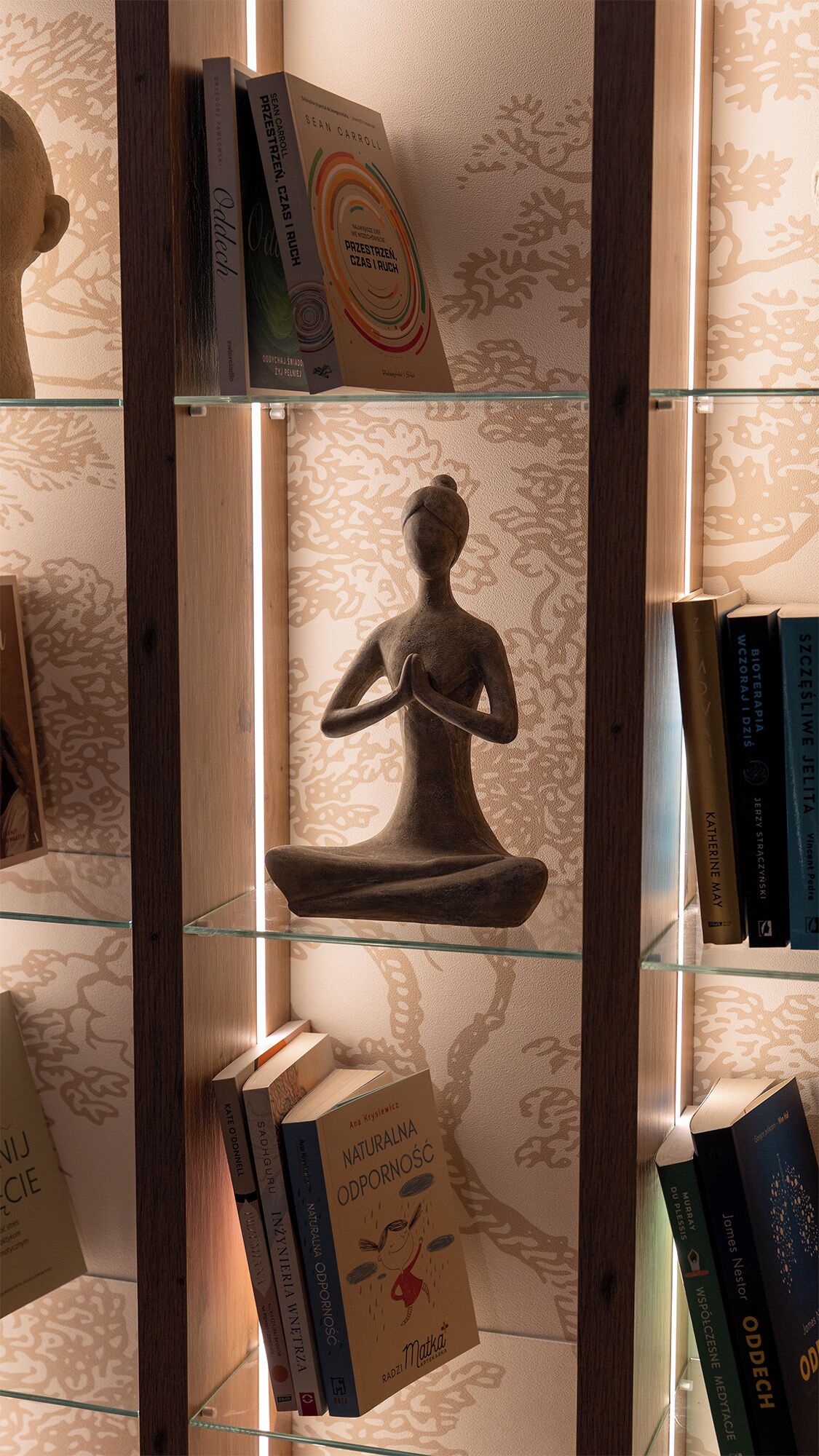 Une bibliothèque remplie de livres et une sculpture.