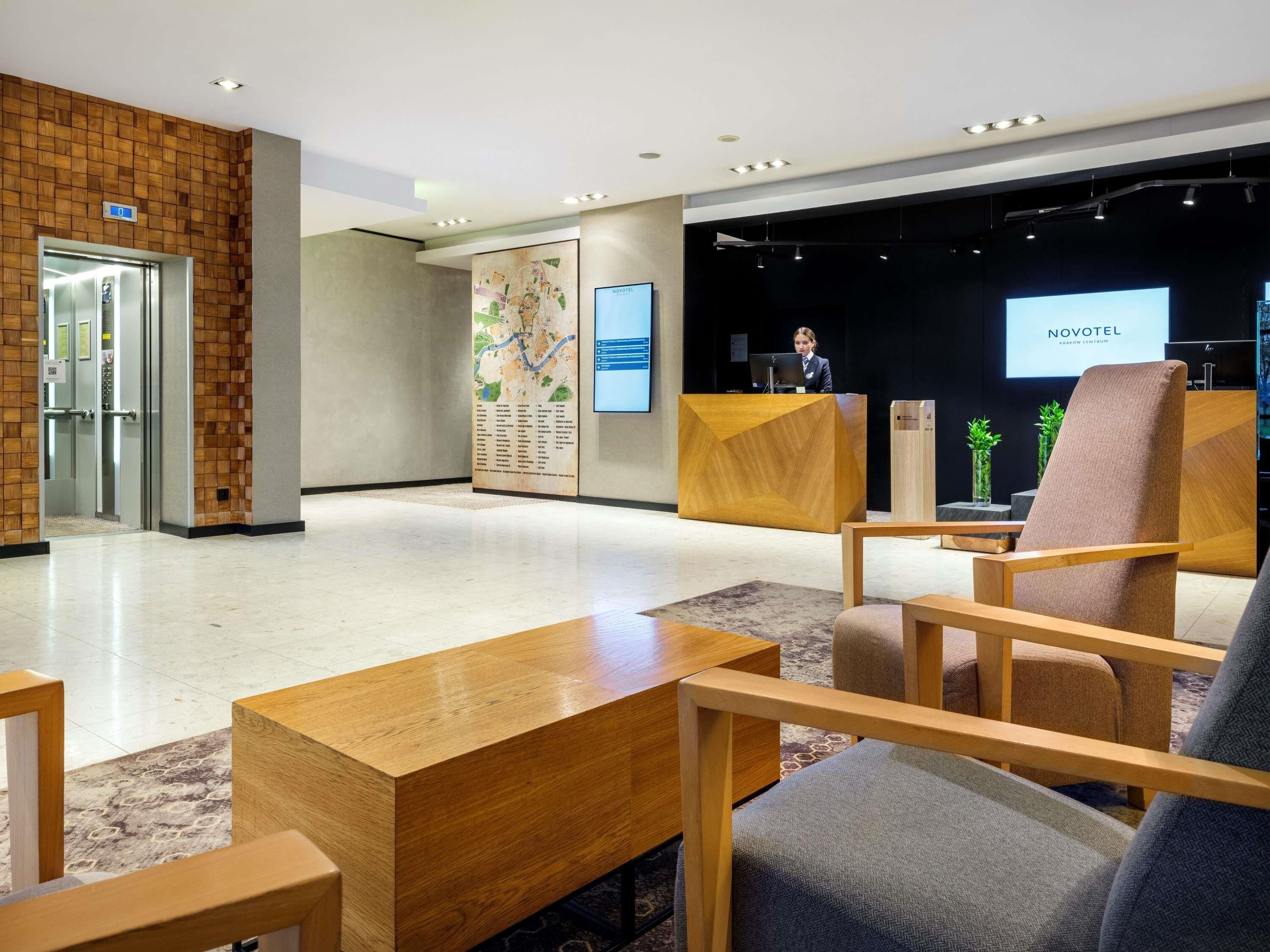 A hotel lobby with a reception desk, seating area, and a map on the wall.