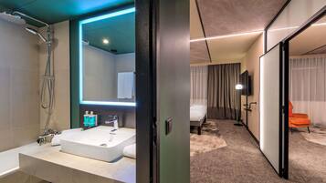Une salle de bain moderne avec un grand miroir, une baignoire et une douche.