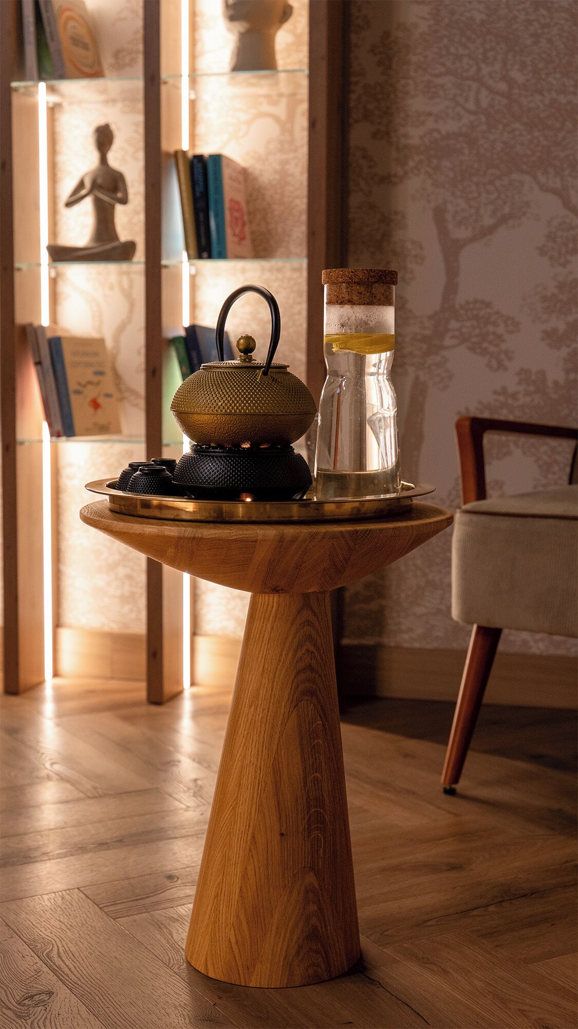 Una mesa de madera con una tetera y un tarro de vidrio.