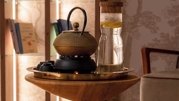 Una mesa de madera con una tetera y un tarro de vidrio.