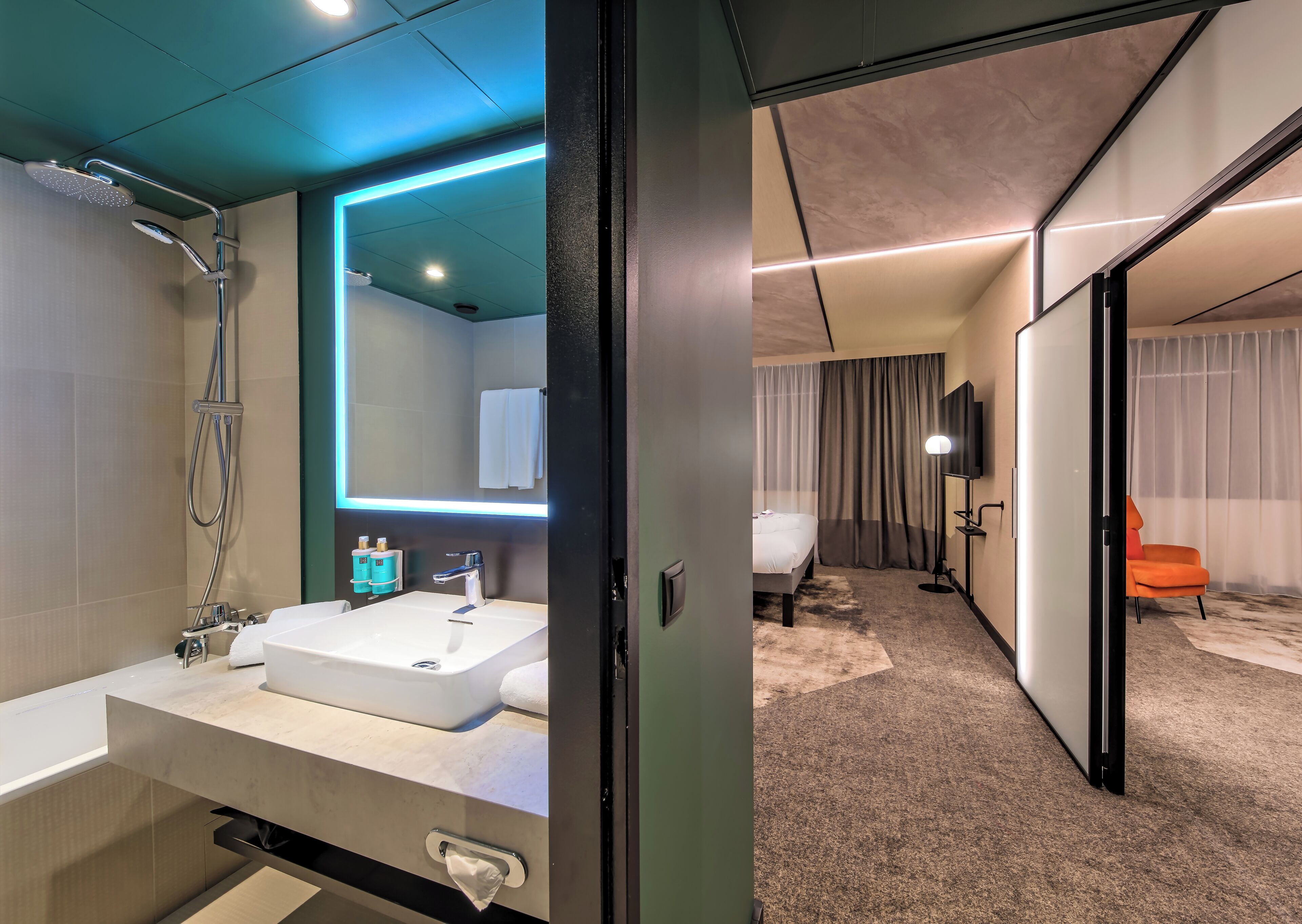 A modern bathroom with a shower, sink, and mirror.