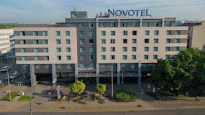 A multi-story hotel with a prominent 'Novotel' sign, featuring a modern architectural design with a flat roof and a uniform facade. - Novotel Krakow Centrum (Kraków)