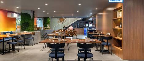 Un restaurante moderno con varias zonas de estar, incluyendo un bar y una barra.