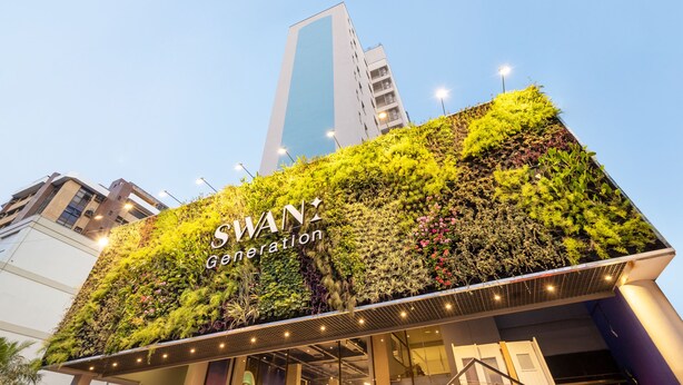 A building with a vertical garden facade and the name "SWAN Generation" prominently displayed.