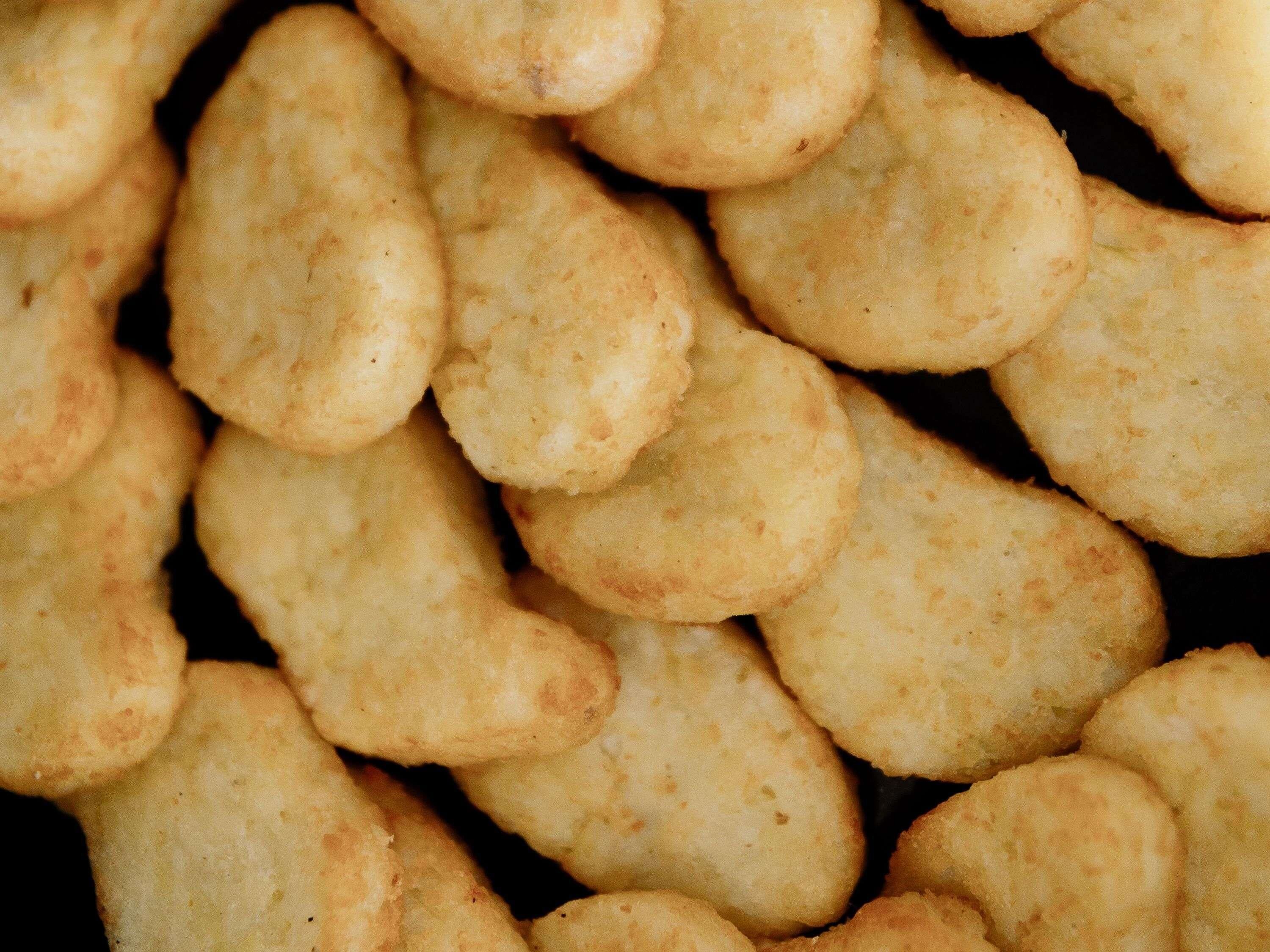 A close-up of uniformly shaped, golden-brown biscuits.