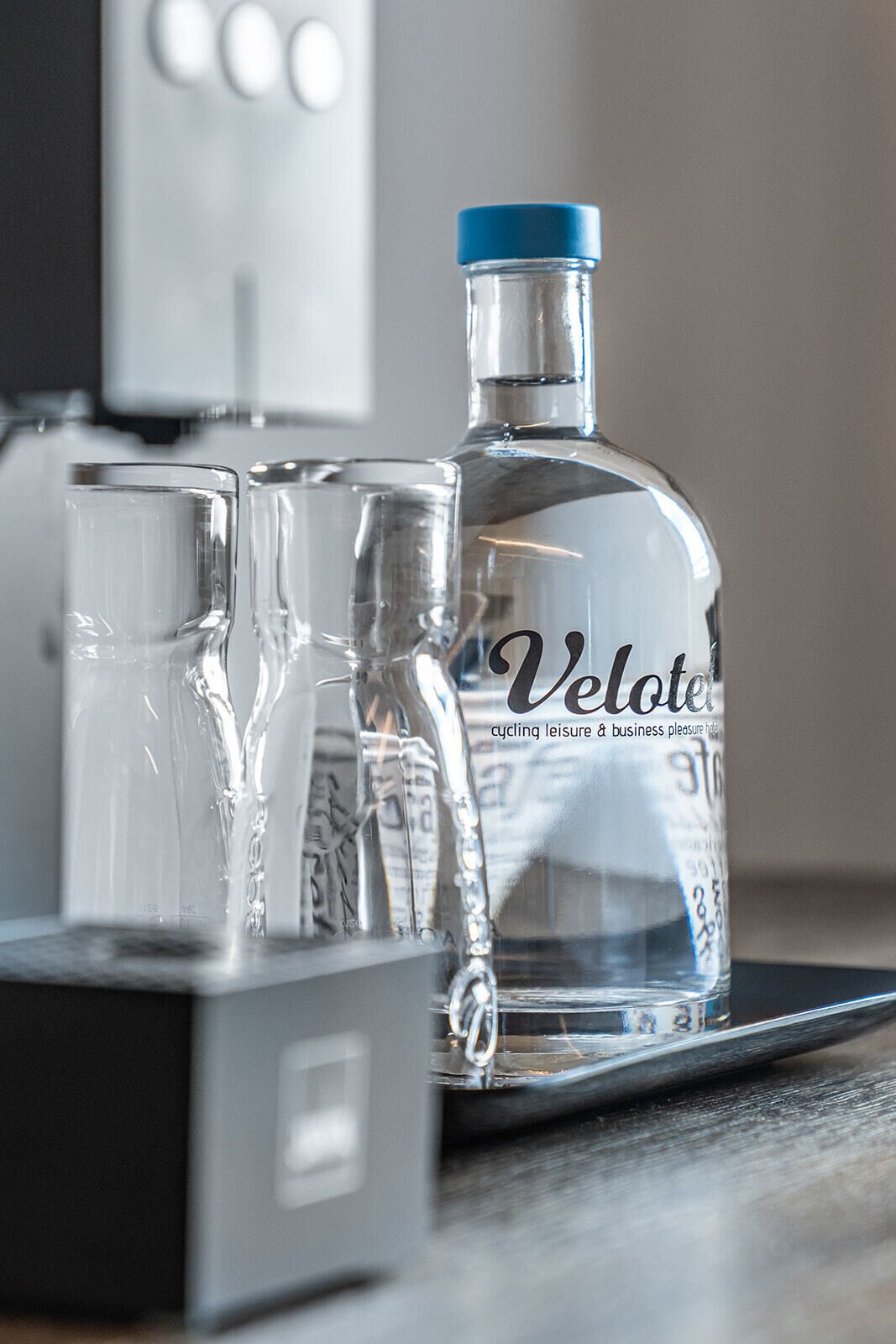 A Velote bottle and two glasses on a tray.