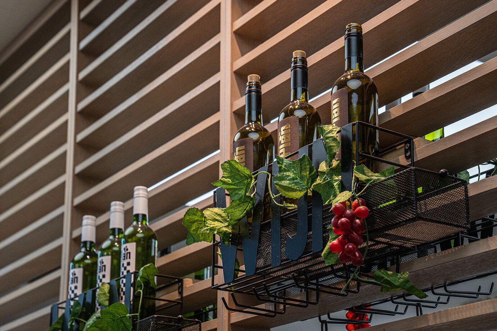 A wine rack with bottles and grapevines.