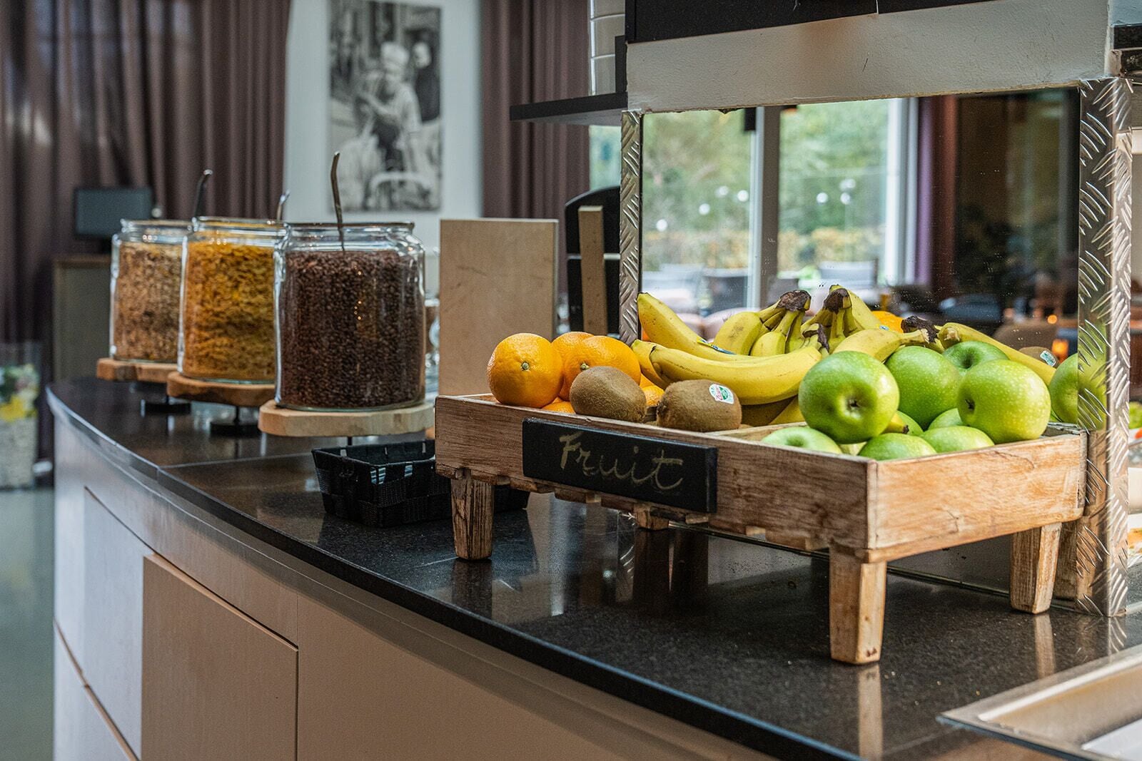 A breakfast bar with a variety of fruits and a coffee station.