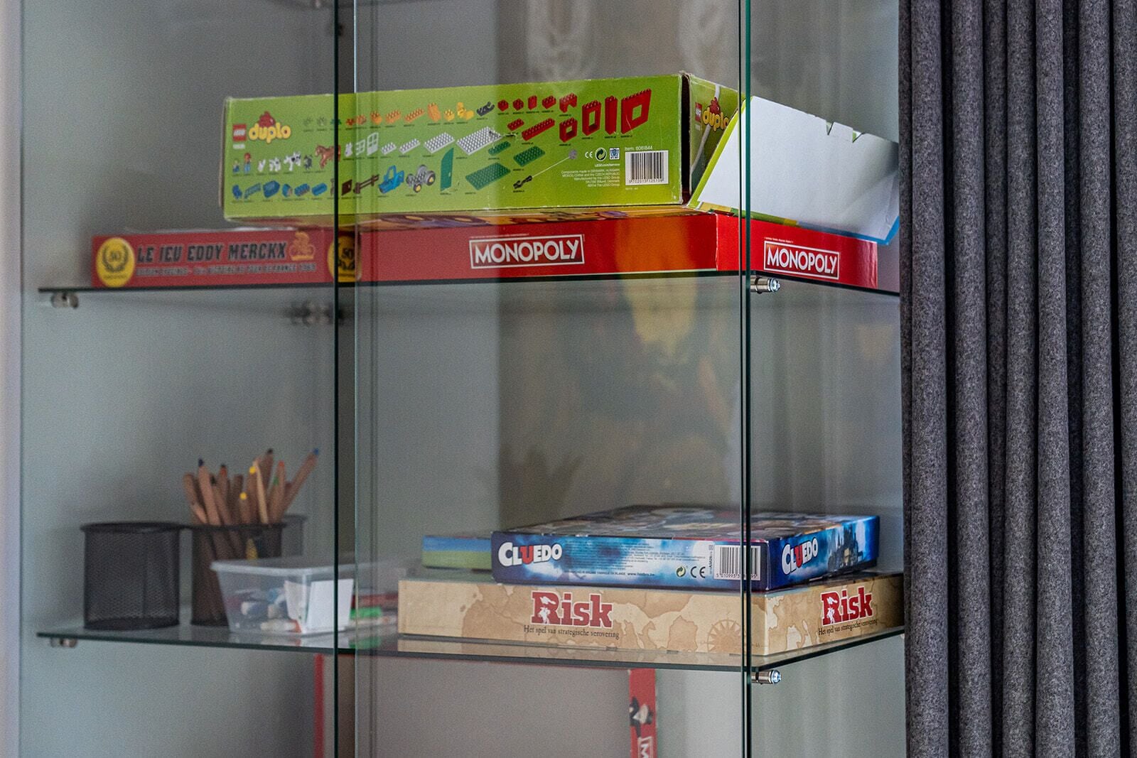 Vitrine de vidro com jogos de tabuleiro como Monopoly e Cluedo.