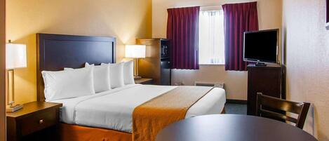 A hotel room with a bed, bedside tables, a television, a desk, and a chair.