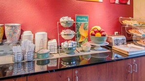 A breakfast buffet with various food items, including waffles, fruit, and cereal. - Quality Inn & Suites Springfield - Eugene North (Springfield)