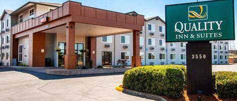 L’entrée d’un hôtel, avec une enseigne indiquant « Quality Inn & Suites 3550 ».