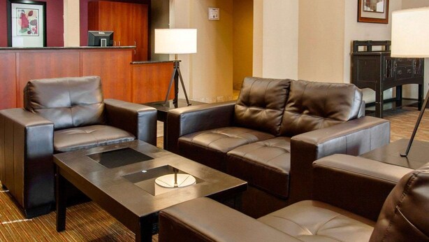 A hotel lobby with leather sofas, a reception desk, and a lamp. - Quality Inn & Suites Springfield - Eugene North (Springfield)