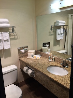 A bathroom with two sinks, a toilet, a towel rack, and a mirror. - Quality Inn & Suites Springfield - Eugene North (Springfield)