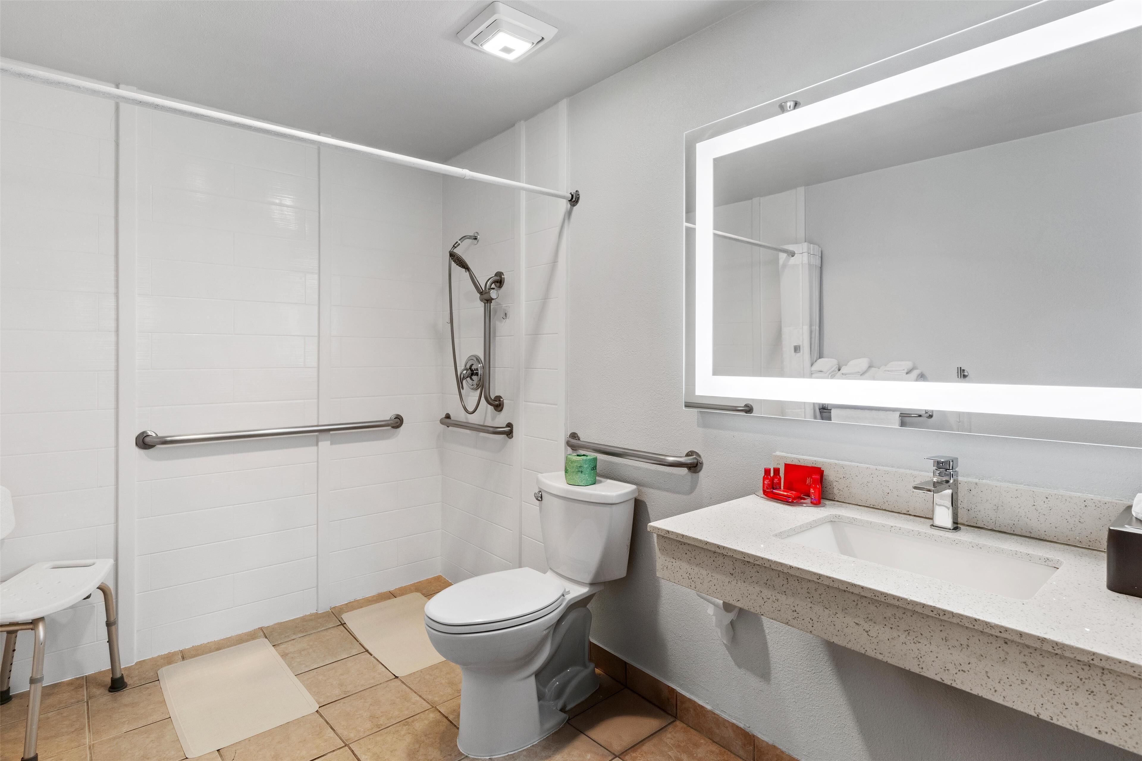 A modern bathroom with a toilet, shower, and sink.