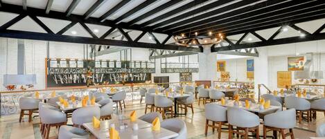 A restaurant with a modern interior, featuring a high ceiling with exposed beams, a central chandelier, and a variety of seating arrangements including tables and chairs.
