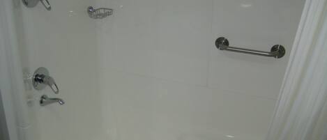 Un baño con bañera, inodoro y ducha.