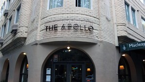 The exterior of The Apollo hotel with a brick facade, arched windows, and a sign for Macleay. - Devere Hotel (Elizabeth Bay)