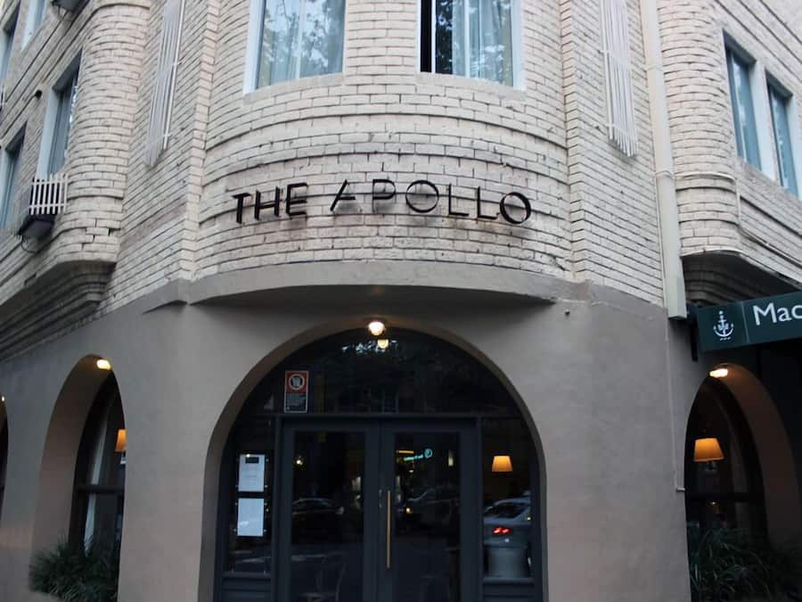 Exterior del hotel The Apollo, con fachada de ladrillo, ventanas arqueadas y un letrero que dice Macleay.