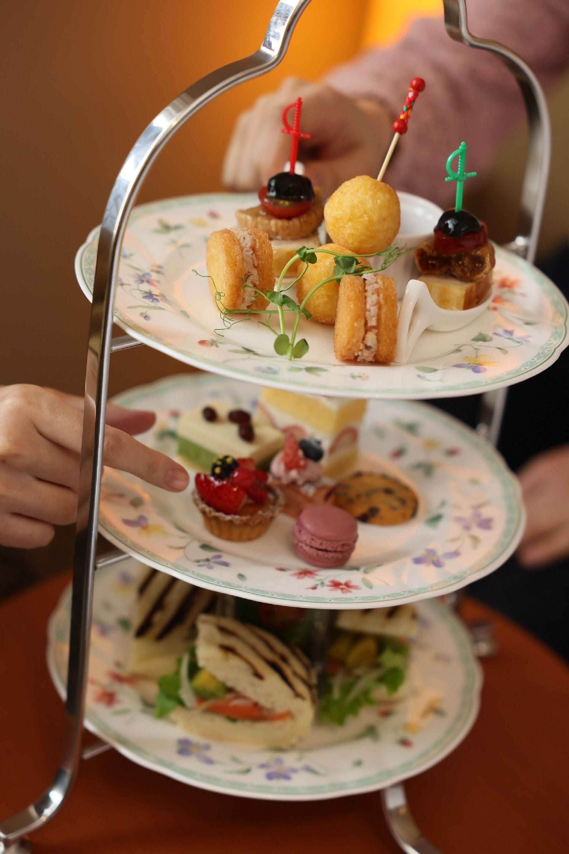 A tiered dessert stand with various pastries and desserts.