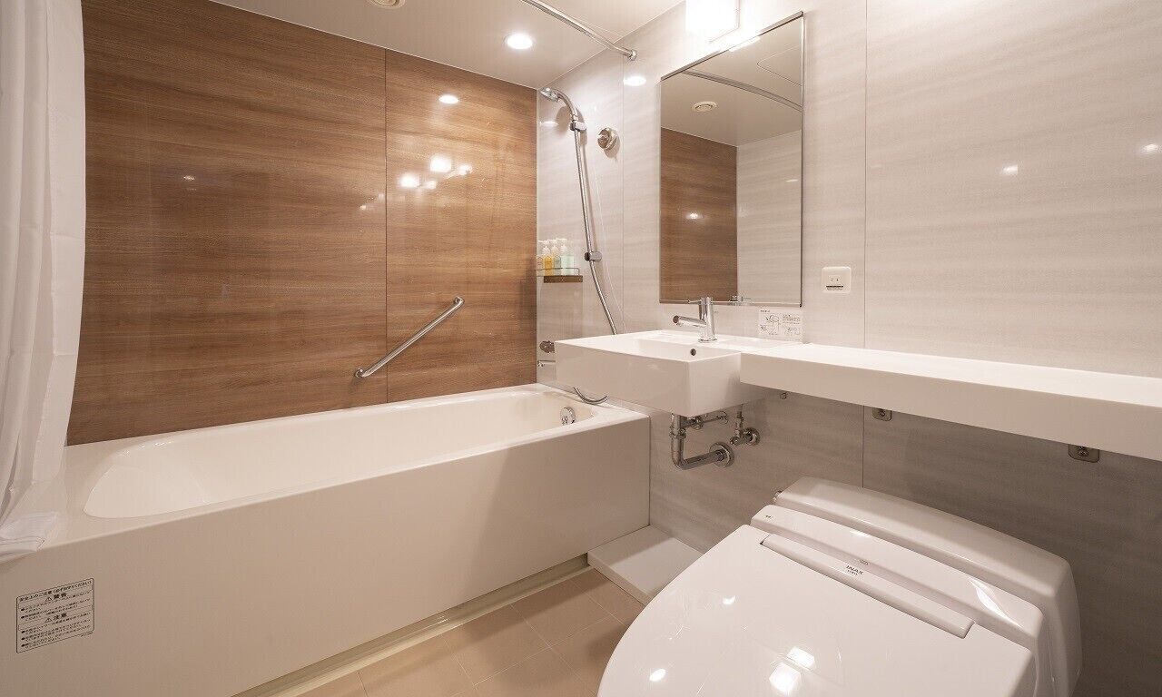 A modern bathroom with a bathtub, a toilet, a sink, and a shower.
