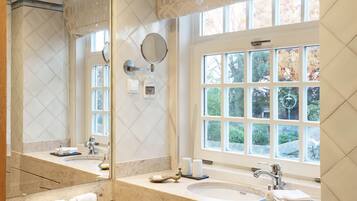 A bathroom with a large mirror, a window, and a sink.