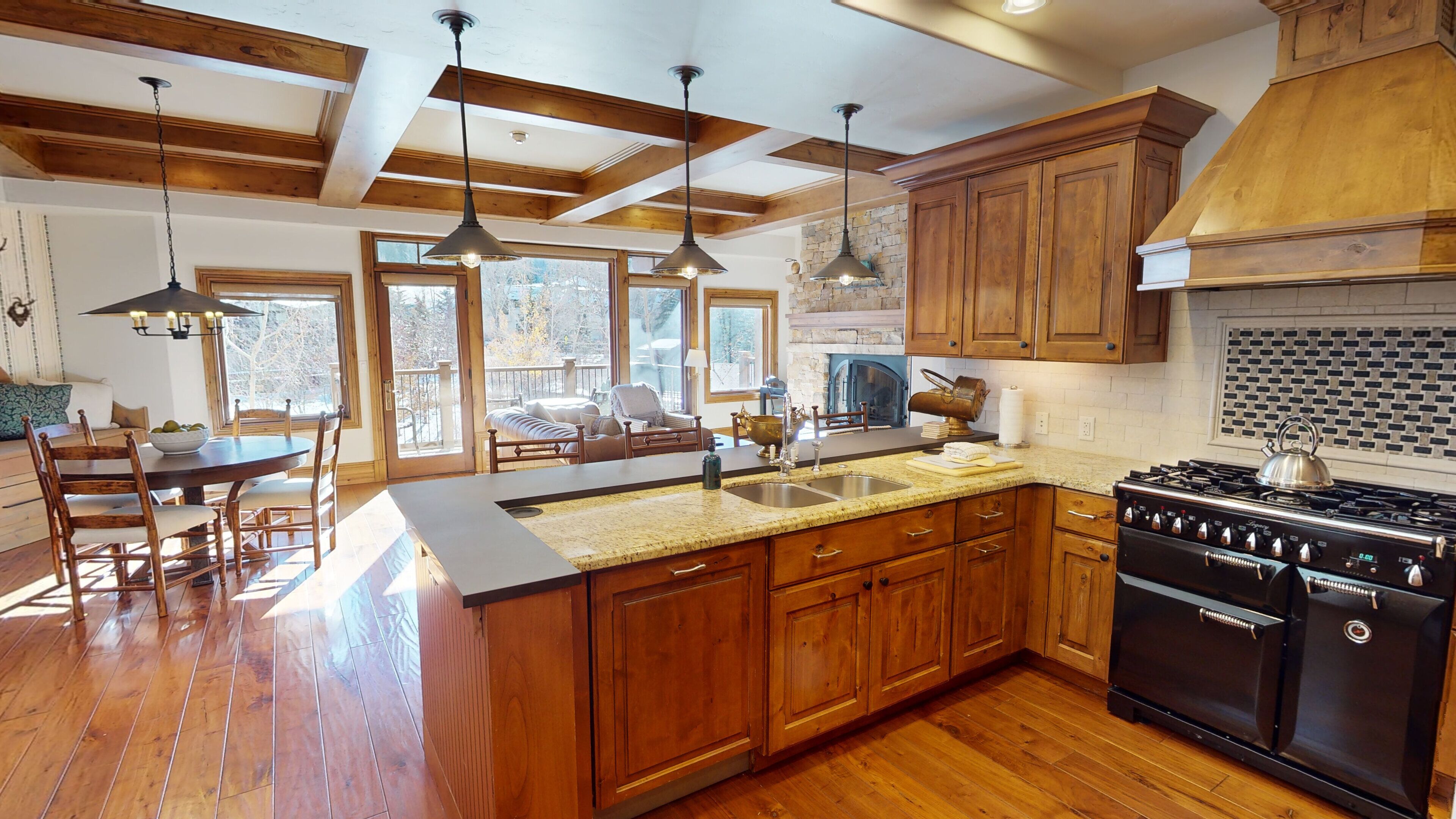 A spacious kitchen with wooden cabinets, a granite countertop, and a large stove.