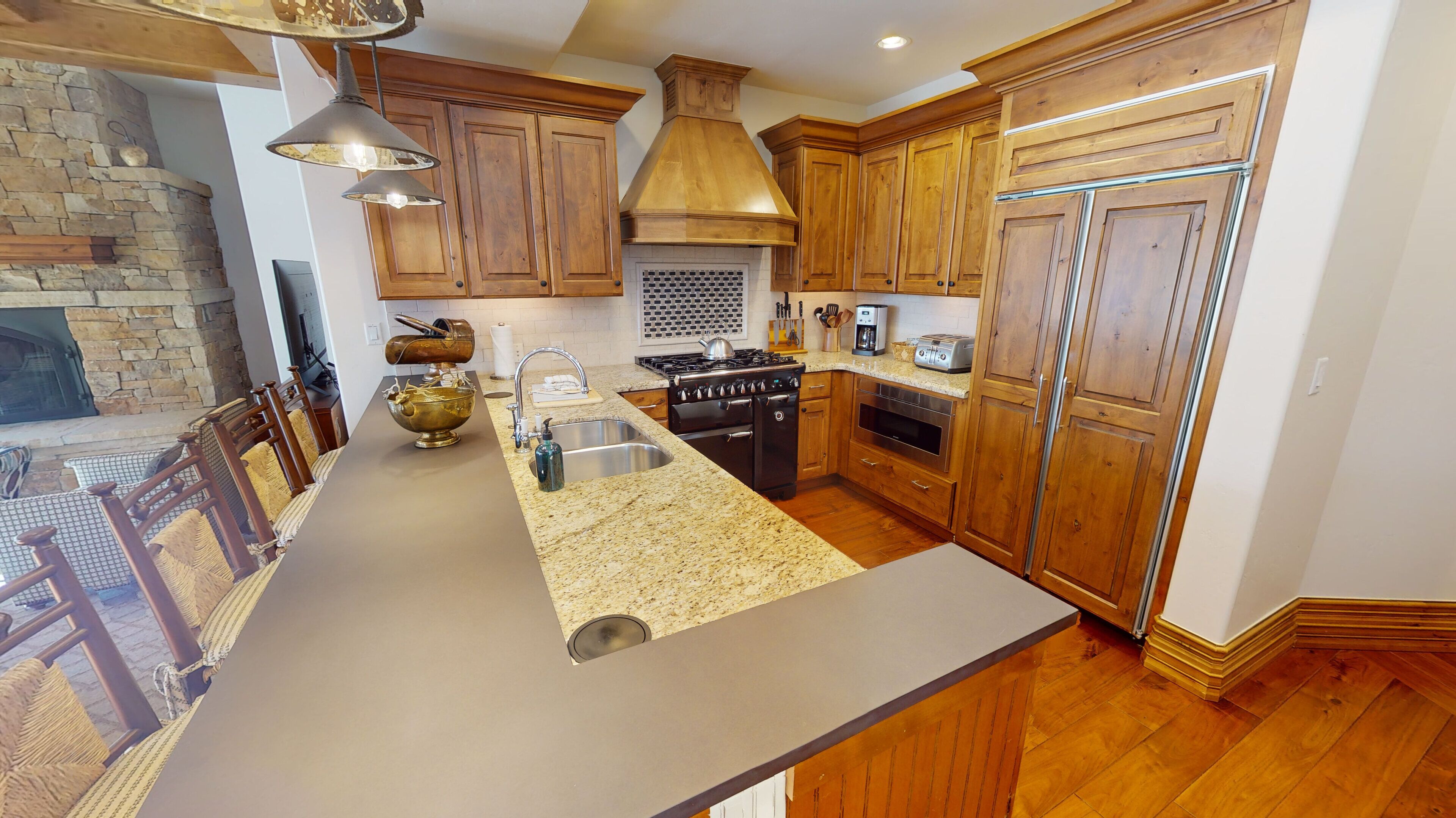 A kitchen with wooden cabinets, a granite countertop, a stove, and a built-in oven.