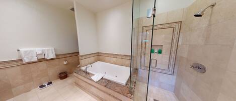 A modern bathroom with a glass-enclosed shower, a bathtub, and a toilet.