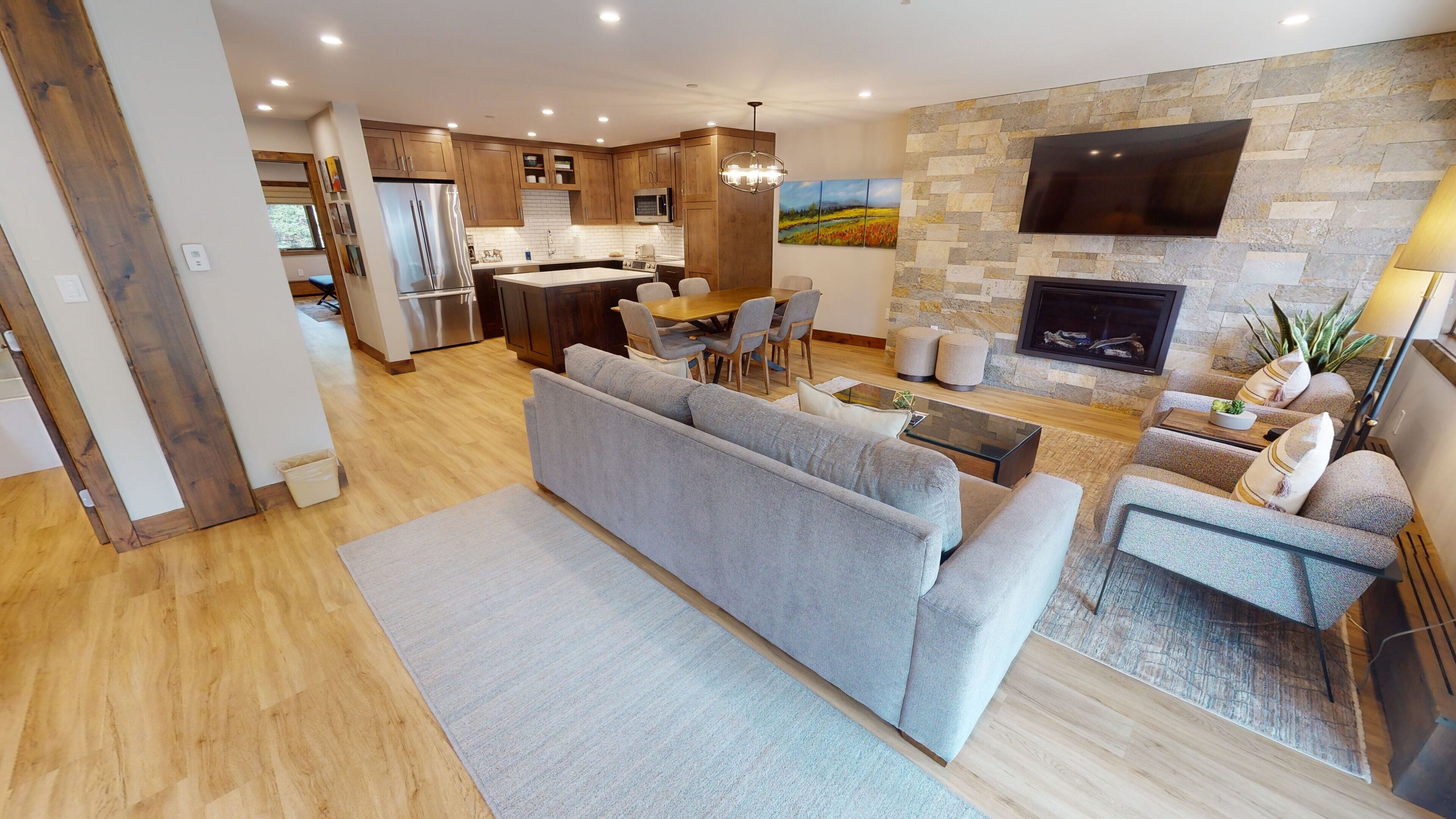 A modern living room with a grey sofa, a coffee table, and a fireplace.