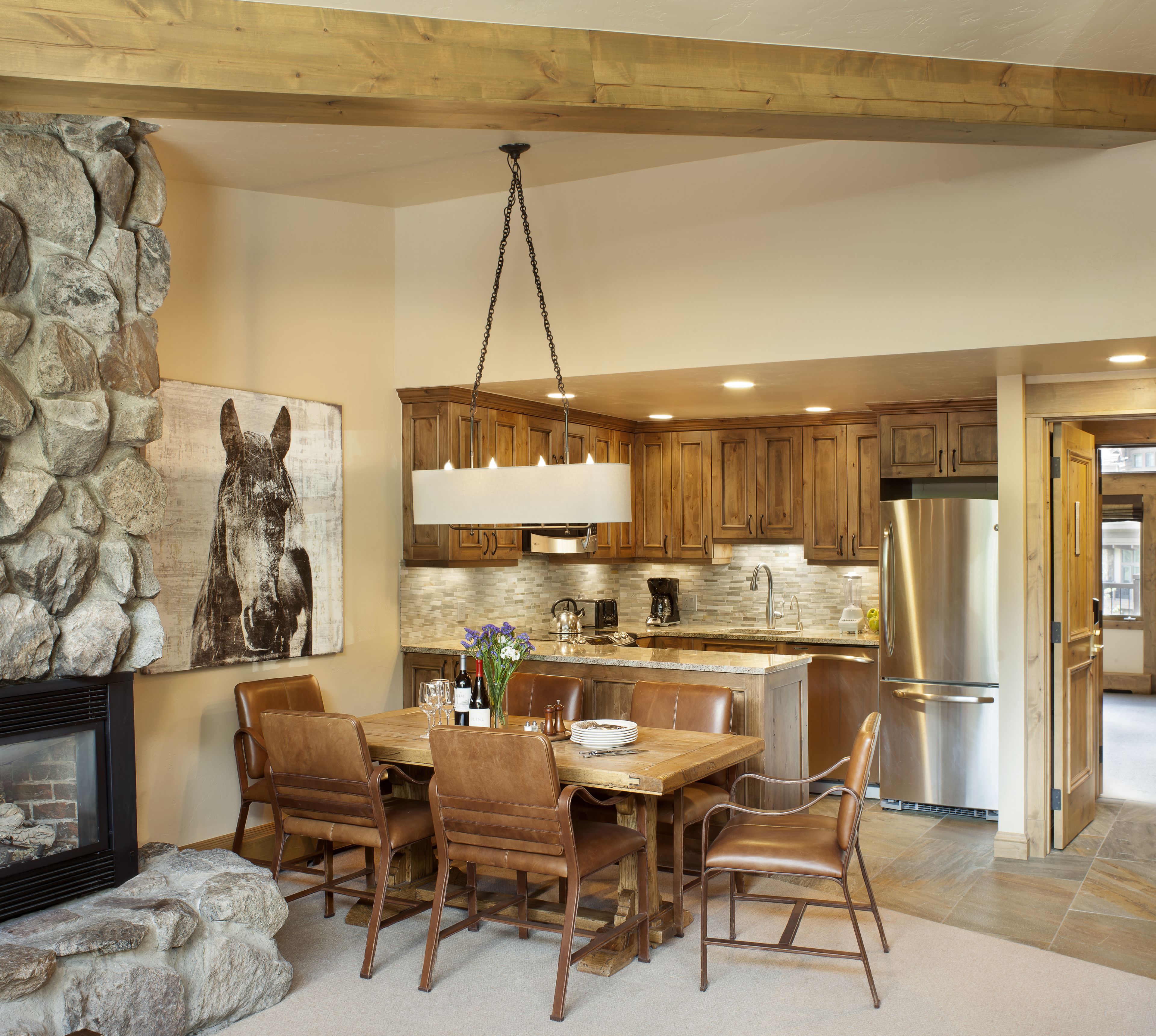 A spacious kitchen with wooden cabinets, a central island, and a stainless steel refrigerator.