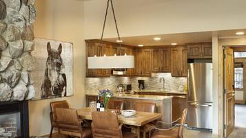 A spacious kitchen with wooden cabinets, a central island, and a stainless steel refrigerator.