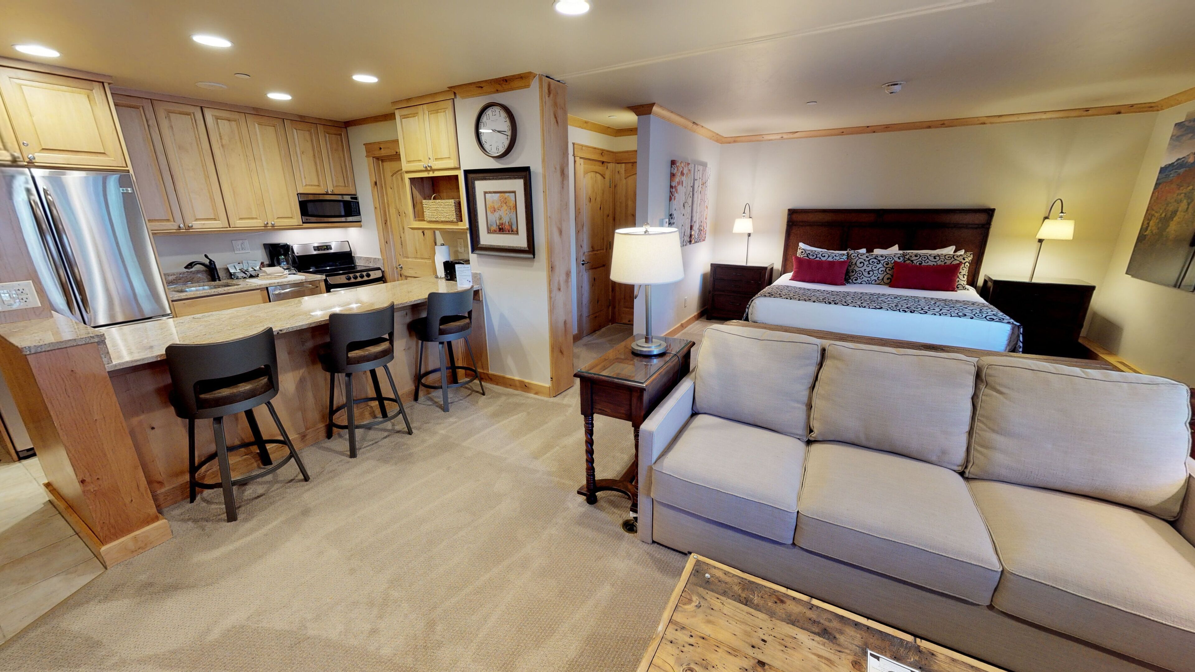 A compact living space with a kitchenette, a sofa, a bed, and a dining area.