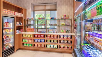 Zona de exhibición de aperitivos y bebidas, con secciones refrigeradas y estantes llenos de diversas opciones.