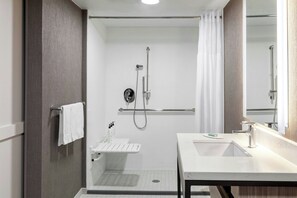A modern bathroom with a walk-in shower, a vanity with a sink, and a mirror. - Springhill Suites By Marriott Denver Westminster (Westminster)