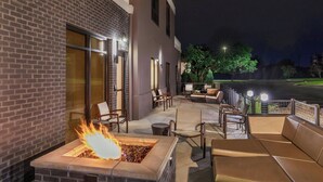 An outdoor patio with a fire feature, seating, and a view of the street. - Springhill Suites By Marriott Denver Westminster (Westminster)