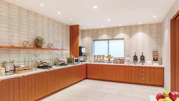 A modern kitchen with wooden cabinets, a microwave, and various food items on the counter.