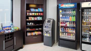 Ein Getränkeautomat, ein Pepsi-Kühlschrank und ein Verkaufsregal für Snacks in der Hotelhalle.