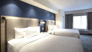 A hotel room with two beds, a nightstand, a phone, and a window with curtains. - SpringHill Suites by Marriott Savannah I-95 (Savannah)