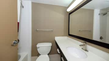 A bathroom with a toilet, sink, and mirror.
