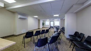 A conference room with rows of chairs, a long table, and a large window.