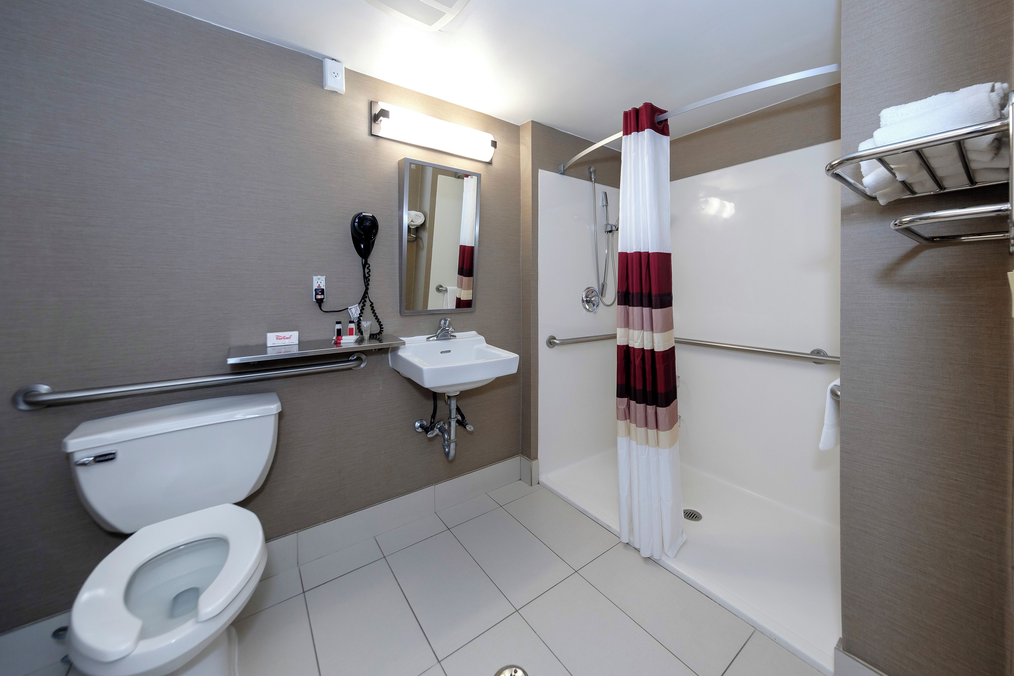 Un baño moderno con inodoro, lavamanos y ducha.
