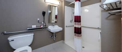 A modern bathroom with a toilet, sink, and shower.