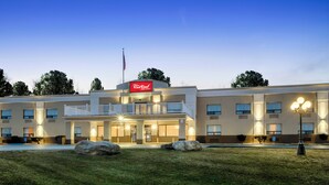 A Red Roof Inn & Suites with a two-story building, a balcony, and a flagpole. - Red Roof Inn & Suites Newburgh – Stewart Airport/ West Point (New Windsor)