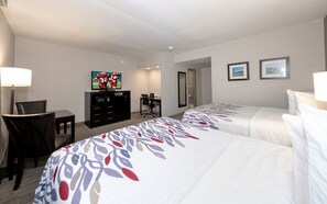 A hotel room with two beds, a desk, a TV, and a chair. - Red Roof Inn & Suites Newburgh – Stewart Airport/ West Point (New Windsor)