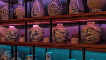 A display of various ceramic vases with intricate designs, arranged on shelves in a well-lit room.