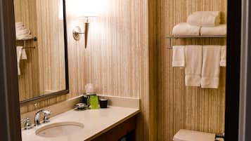 A bathroom with a sink, mirror, towel rack, and toilet.