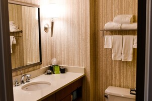 A bathroom with a sink, mirror, towel rack, and toilet.
