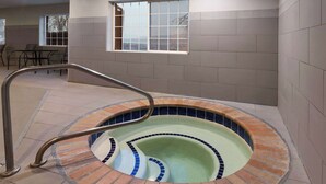 A spa area with a circular hot tub, a metal handrail, and a window with a view. - La Quinta Inn & Suites by Wyndham North Orem (Orem)